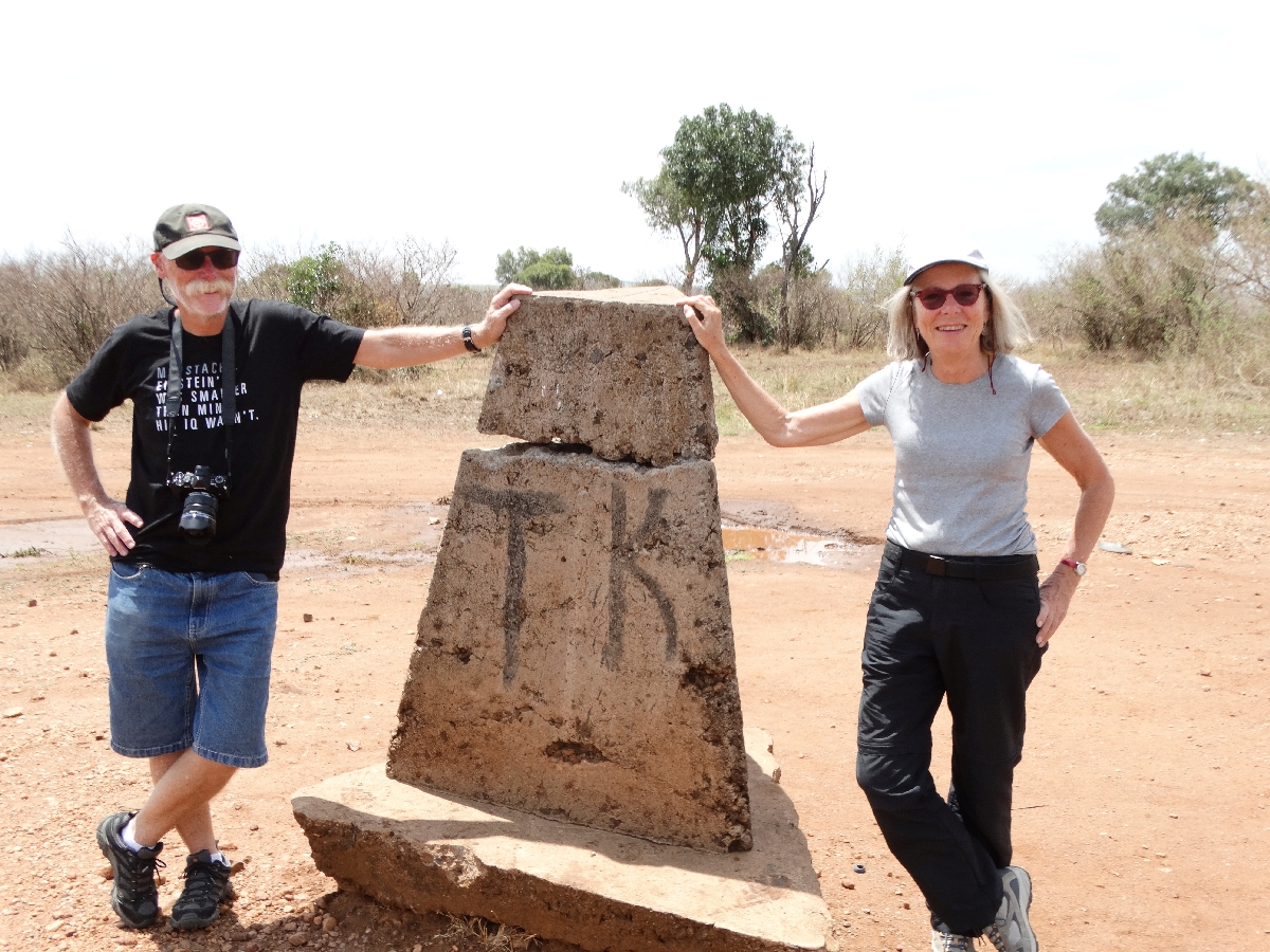 At a cairn marking the border of the Serangetti, Tanzania & Masaimara, Kenya