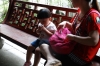 Little girl takes her medicine, Traditional Chinese Medicine shop, Hu Qing Yu Tang, Hangzhou CN